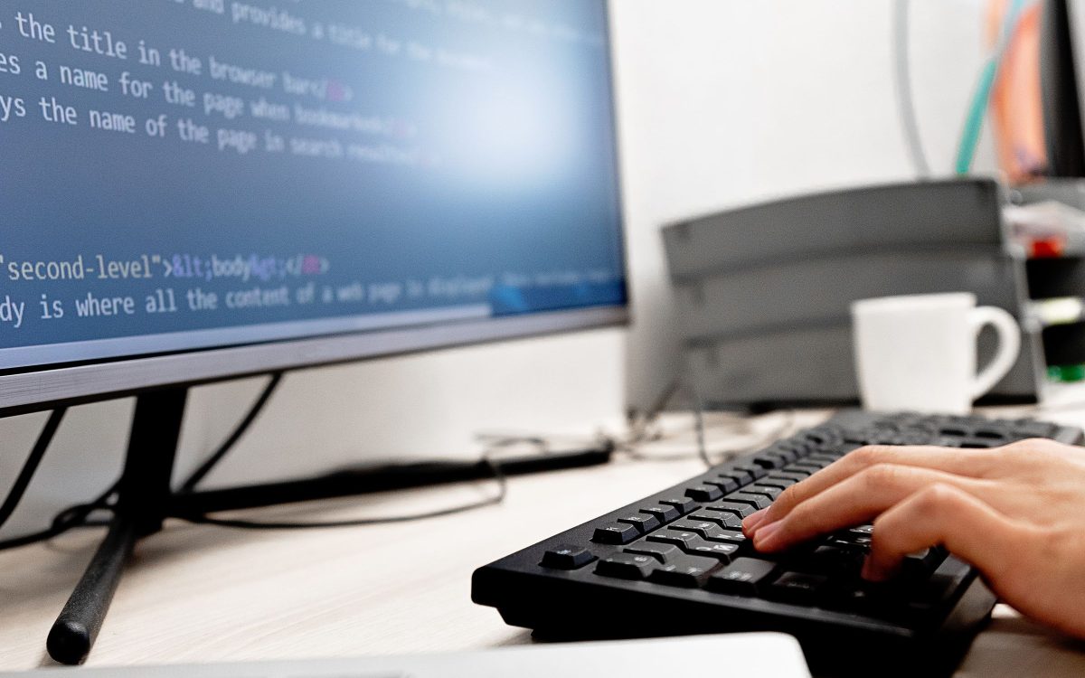 Two people reviewing software on a laptop screen together.